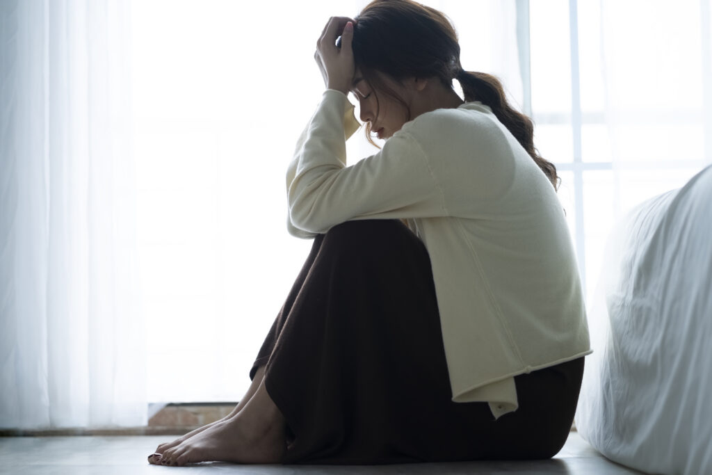 部屋で落ち込む女性