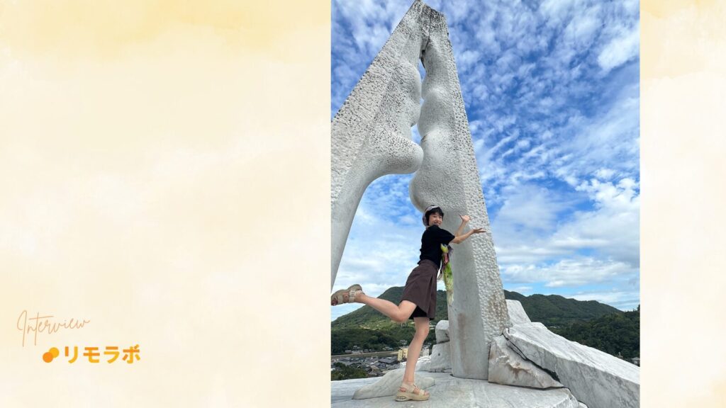 建築物の前でポーズをとる榎本あん