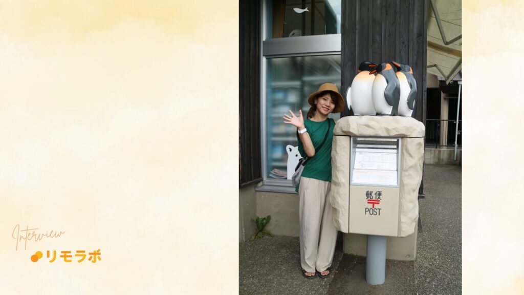 観光地のポストの横でポーズをとるめぐさん